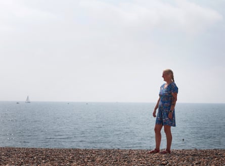 Hildi Mitchell on Brighton beach in a dress and bare feet