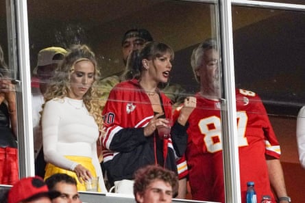 Taylor Swift laughs while talking to Ed Kelce, Travis Kelce's father, during halftime of Thursday's game.