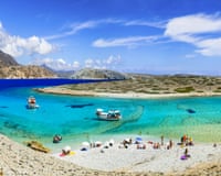turquoise lagoon surrounded by white stone beaches on a Greek island on a hot summers's day