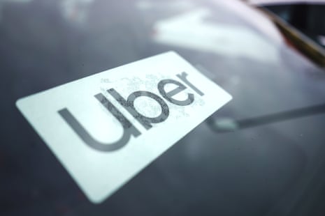 An Uber sign is displayed inside a car windscreen.