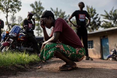 a woman crouches with her hand on her forehead