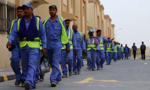 Foreign labourers walk back to their compound.