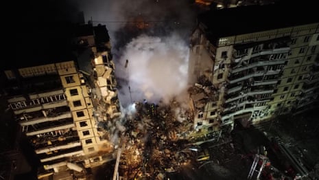 Rescuers dig through rubble of apartment building in Ukraine hit by missile attack – video