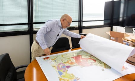 Mauro Antonio Di Vito guarda una grande mappa dei Campi Flegrei su un tavolo del suo ufficio