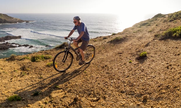 Portugal, Senior man mountain biking at the sea, Alentejo