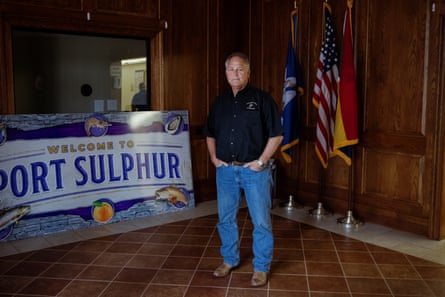 A middle-aged man stands in front of a “Welcome to Port Sulphur” sign.