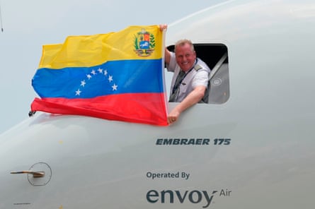The pilot of the US aircraft holding a Venezuelan flag from the cockpit window after landing in Venezuela.