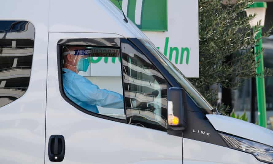 A driver relocates quarantining hotel guests at the Holiday Inn near Melbourne airport after an outbreak of the UK variant of Covid at the hotel.