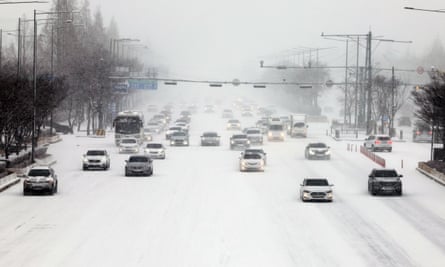 Cars move slowly on a road amid heavy snowfall in Gwangju, South Korea on Tuesday.