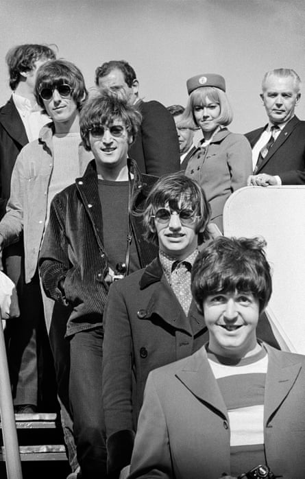 The band pictured descending some stairs with airport staff behind them