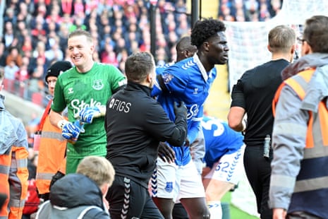 Onana is helped out of the advertising hoardings.