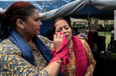 Two women comfort each other