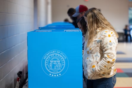 people stand at voting booths