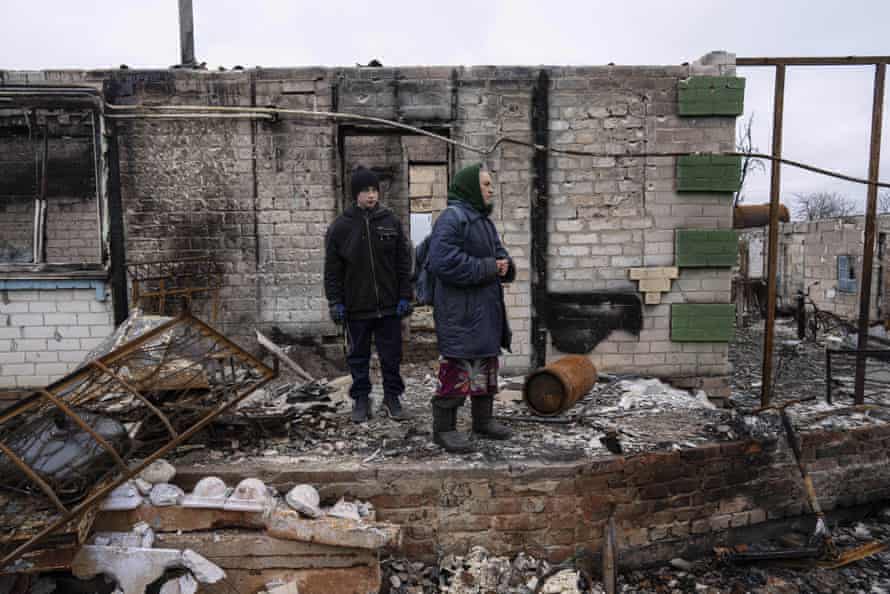 Danyk Rak, 12, and his grandmother Nina Vynnyk stand on the debris of their house which was destroyed by Russian forces’ shelling in the outskirts of Chernihiv, Ukraine.
