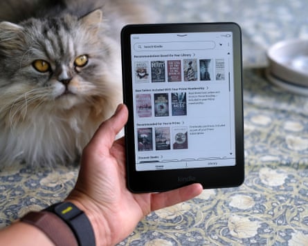 Kindle Paperwhite on a table next to a long-haired cat