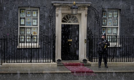 Hail falls as a police officer stands guard outside 10 Downing Street in London