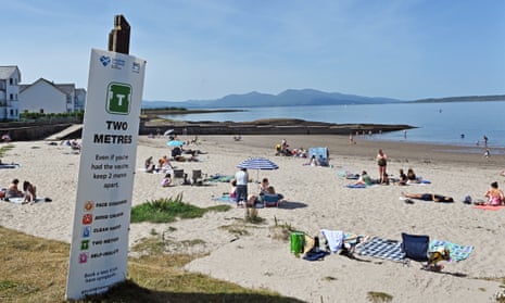 A sign at Ganavan Sands in Oban urges people still to take precautions and observe social distancing as they enjoy the beach on what was the hottest day of the year in parts of Scotland.