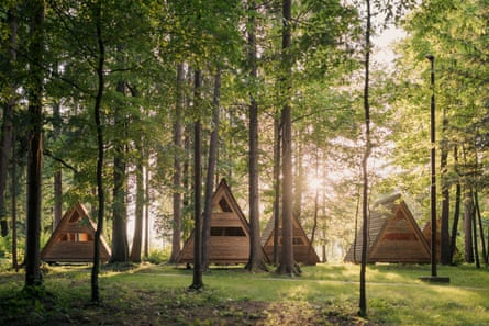 tipi-shaped A-frame wooden cabins in a forest
