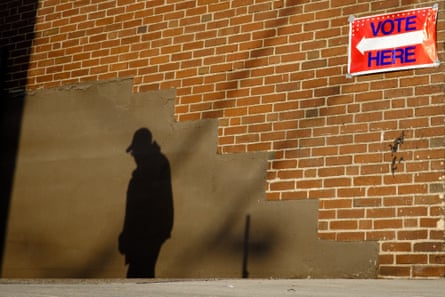 The early morning sun casts the shadow of a voter on a wall as he arrives at a polling location in Aliquippa, Pennsylvania, U.S.