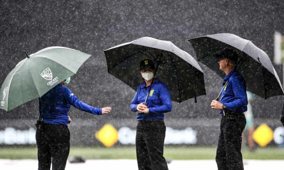 Umpires inspect the Adelaide Oval pitch during rain delays in the third T20, which was ultimately abandoned amid the downpour.