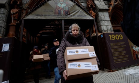 People carry humanitarian aid, which are stored in St. Nicholas Cathedral, in Kyiv, brought from various countries to be sent to Kherson (Photo by Mustafa Ciftci/Anadolu Agency via Getty Images)