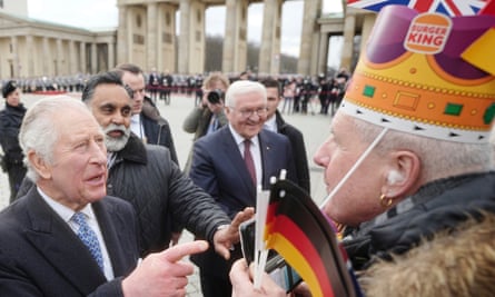 Prince Charles greets fans wearing Burger King hats at the Brandenburg Gate in Berlin