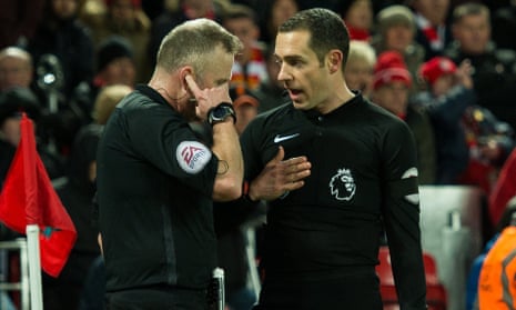 Jon Moss (left) talks with his assistant Eddie Smart and with the fourth official via his earpiece before awarding a penalty to Tottenham.