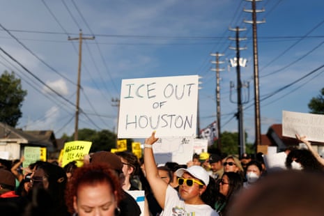 A woman holds a sign reading "ICE OUT OF HOUSTON" during a protest in July.
