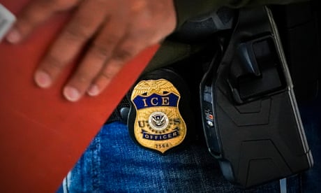 Gold and blue Ice badge on man's jeans, next to gun