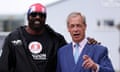 Farage points to the camera while speaking, while Derek Chisora, wearing a union jack bandana, rests an arm on Farage's shoulder