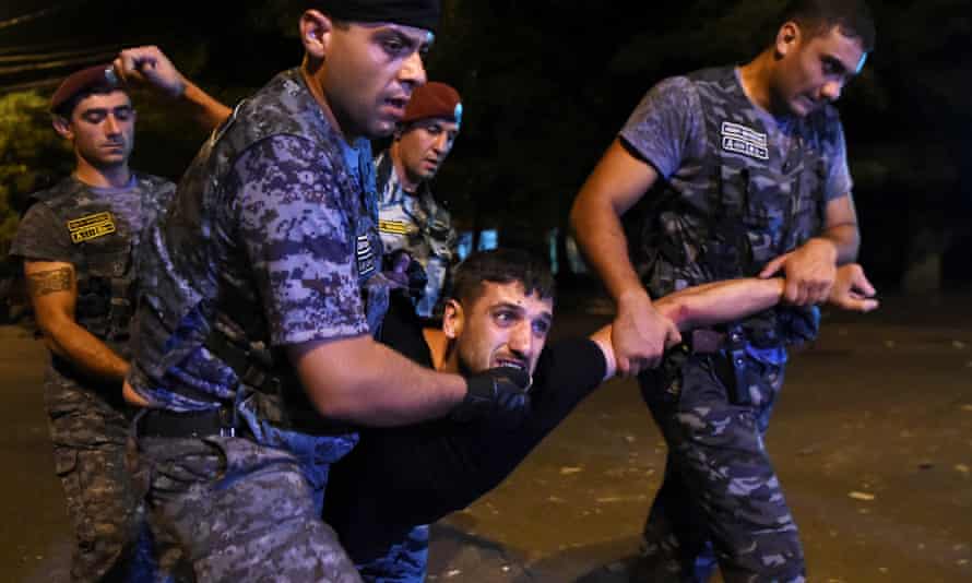 Police officers detain a protesters during demonstration in Yerevan