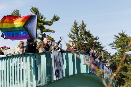 People with a rainbow pride flag along a bridge