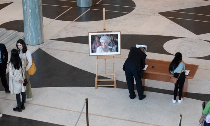 Members of the public queue to sign a condolence book in the entrance to the Australian parliament to mark the death of Queen Elizabeth II.