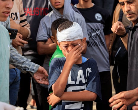 Injured Palestinian child, Yousef Al-Bayouk, weeps over his brothers, Moath and Moataz, who were killed in Israeli strikes, as mourners attend their funeral, at Nasser hospital in Khan Younis, southern Gaza Strip on 15 May 2025.
