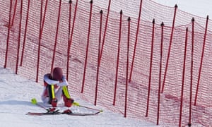 Mikaela Shiffrin sits on the side of the course after missing a gate early in the first slalom run.