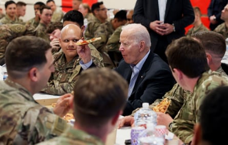 Joe Biden eats pizza with soldiers at a barracks table