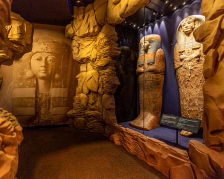 An exhibit with wooden coffins behind a glass screen