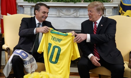 Brazilian president Jair Bolsonaro presents Donald Trump with a national team soccer jersey at the White House, March 2019.