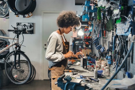 A bicycle mechanic works in her shop.