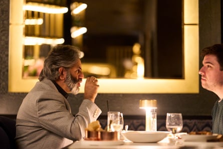 Two men facing each other across a restaurant table