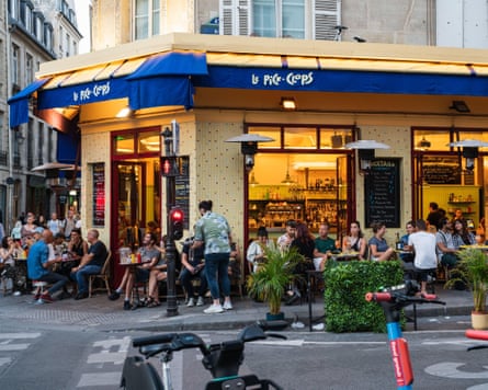 People walking and dining in cafe in the evening in famous the Marais district in Paris