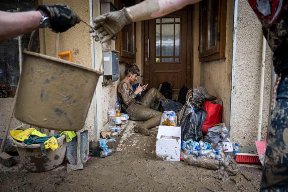 Volunteers drag mud from the physiotherapy site to the street, while assistants are resting