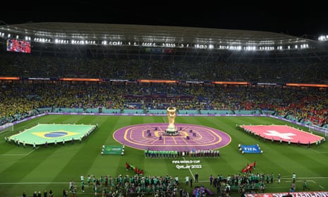General view of a giant FIFA World Cup replica trophy on the pitch alongside Brazil and Switzerland flags before the match as the players line up ahead of the national anthems.