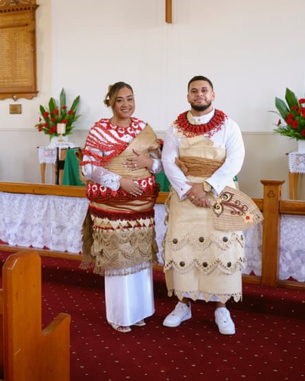 A newlywed couple wearing traditional dress poses for a photo