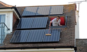 Woman cleaning dust of her solar panels with a broom