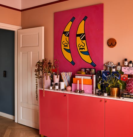خزانة جانبية مكتظة بأبواب برتقالية زاهية، وصورة خلفية حمراء على جدران برتقالية شاحبة