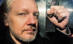 Julian Assange gesturing from a prison van in May.