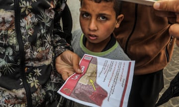 A boy holds a flyer with orders to evacuate 