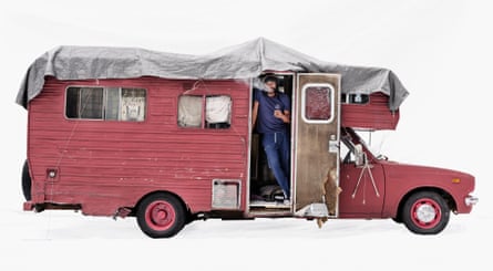 Expressionist artist Pat in a pink Toyota campervan in Santa Monica, California, US. He is stood in the doorway, vaping