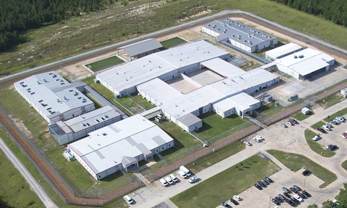 Aerial view of the South Louisiana ICE Processing Center, showing multiple secured buildings, perimeter fencing, and surrounding grounds.